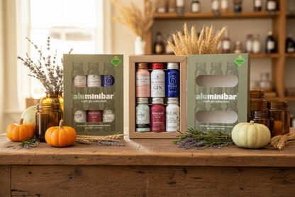 Aluminibar craft gin collection in a box on a wooden surface with decorative items.